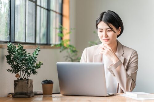パソコンで調べ物をする女性の画像